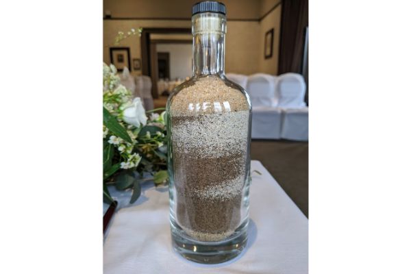 different coloured sand in a sealed bottle on a table
